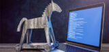 trojanisches Pferd vor aufgeklapptem Laptop