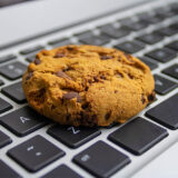 Ein Cookie liegt auf einer Tastatur
