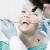 Zahnarzt behandelt Patientin in Praxis
