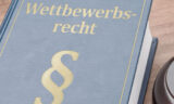 Blaues Buch mit dem Titel Wettbewerbsrecht und Paragraphenzeichen.