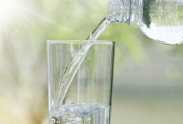 Wasser aus einer Flasche wird in ein Glas gefüllt