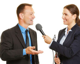 Pressesprecher gibt Journalistin mit Mikrofon ein Interview