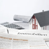 Immobilienzeitung mit Haus im Hintergrund