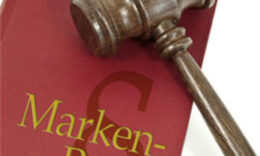 Richterhammer, der auf einem roten Buch mit der Aufschrift "Markenrecht" liegt