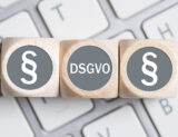 DSGVO und Paragraphen zeichen auf Würfeln liegen auf Tastatur
