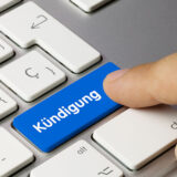 Finger auf Tastatur Button "Kündigung"
