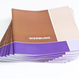 mehrere Zeitschriften mit der Aufschrift "Werbung" auf einem Stapel