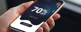 Hand hält Smartphone, auf dem mit 70% Nachlass geworben wird.