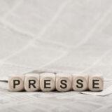 Aufschrift Presse auf Würfeln, die auf Zeitung liegen