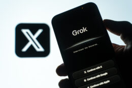 X Label im Hintergrund, KI-Chatbot Grok auf Handy im Vordergrund